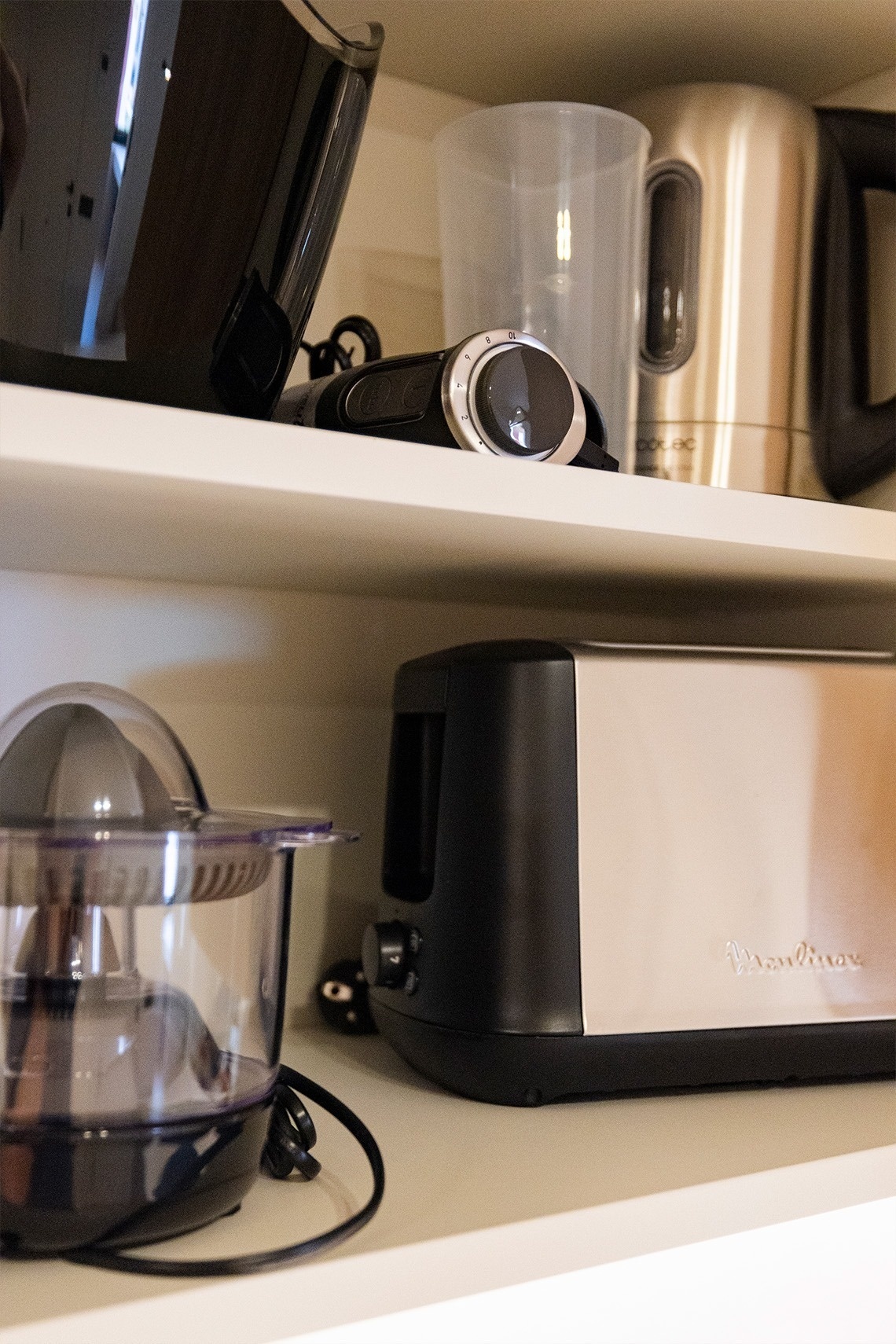 a moulinex toaster sits on a shelf with other kitchen appliances