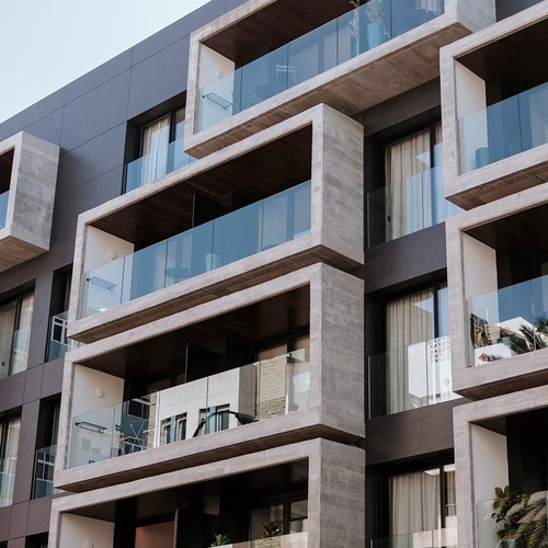 un edificio de apartamentos con balcones de vidrio y madera