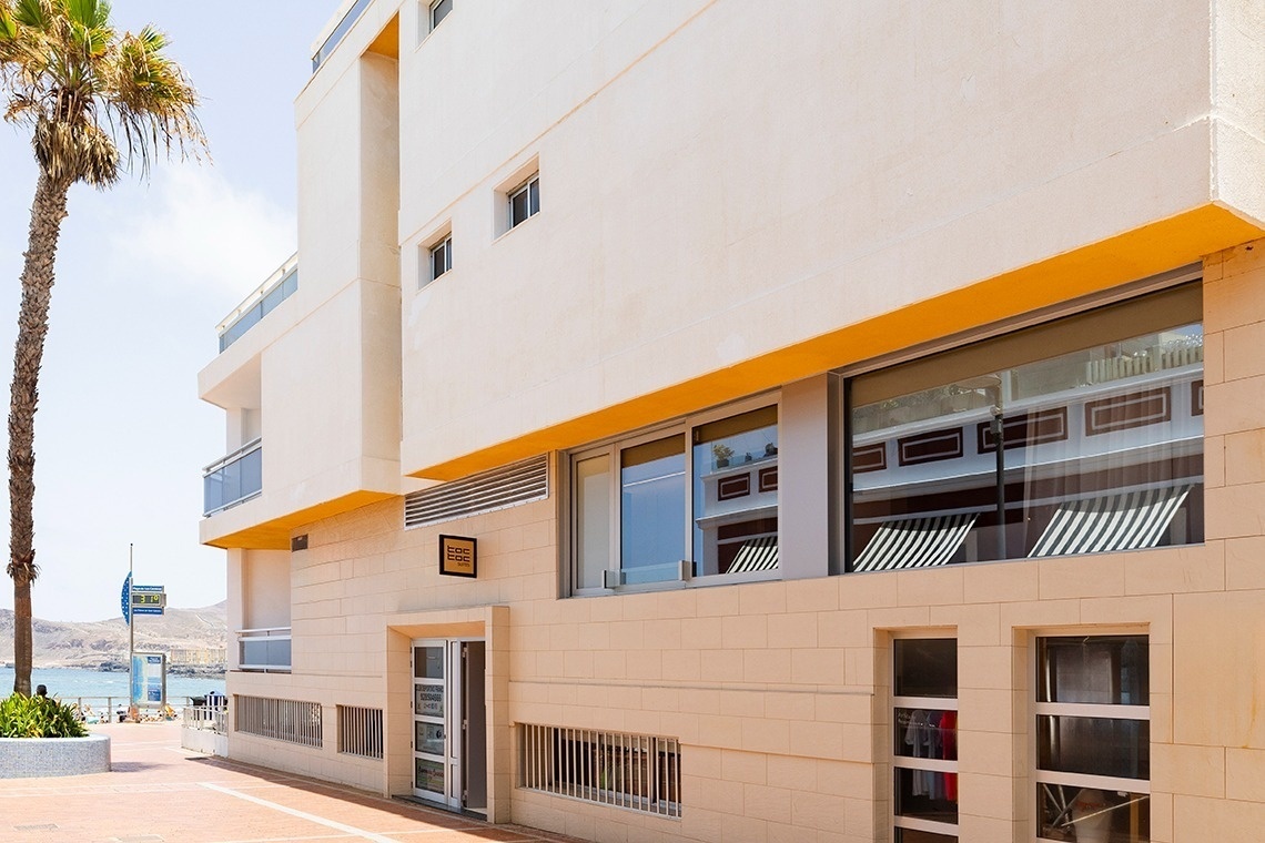 un edificio blanco y amarillo con una puerta amarilla y un letrero que dice ' hotel '