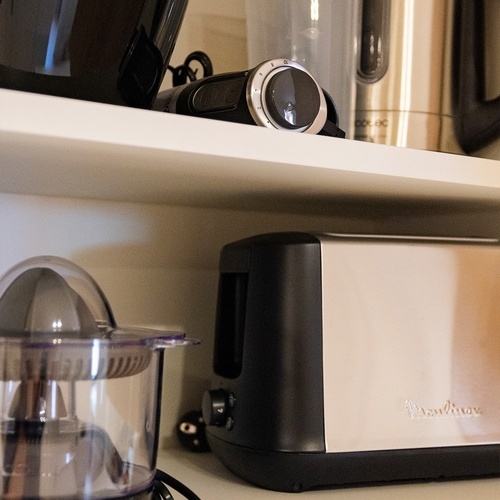 a moulinex toaster sits on a shelf with other kitchen appliances