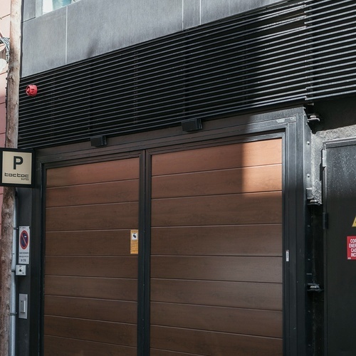 un edificio con una puerta de garaje marrón y un letrero que dice boutique