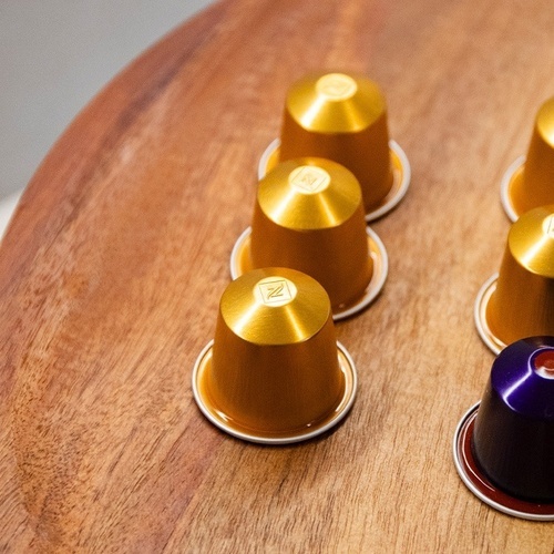 nespresso capsules are lined up on a wooden table