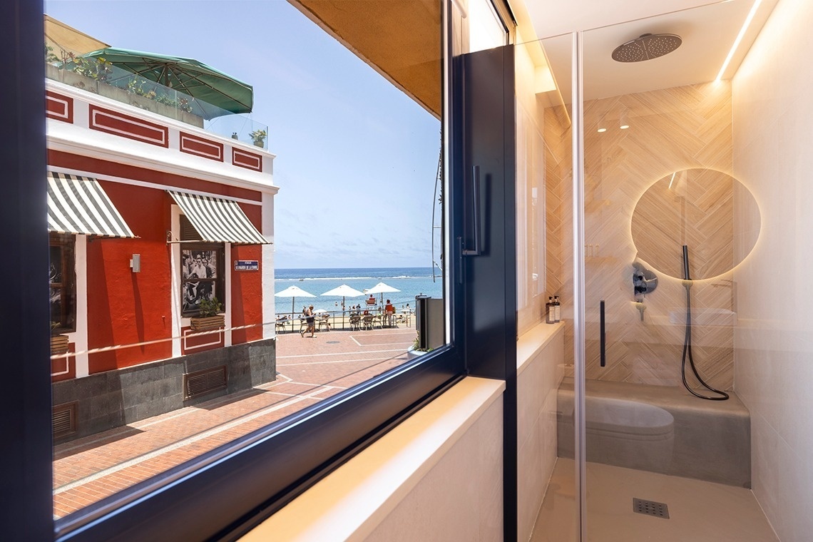 ein Badezimmer mit einer Dusche und einem Fenster mit Blick auf das Meer