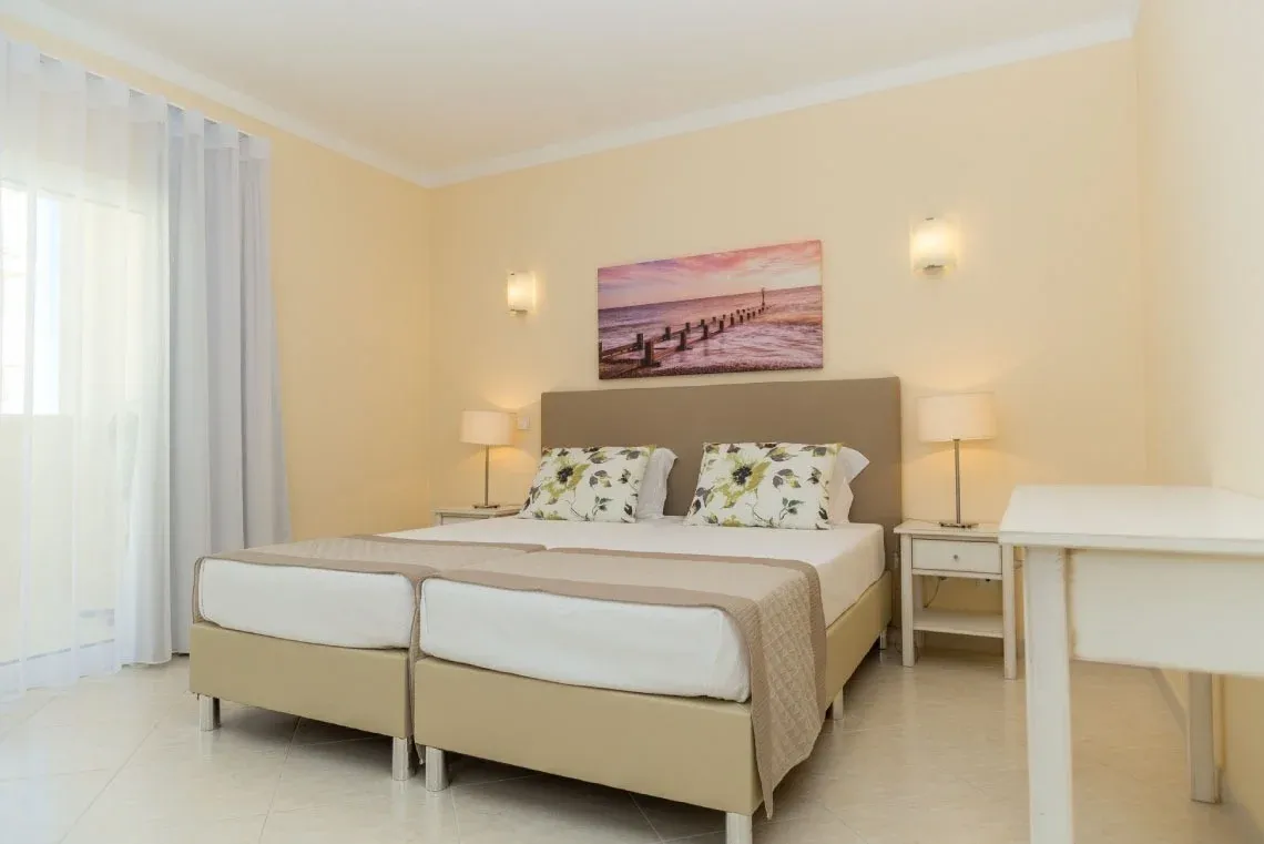 Quarto de hotel com portas de madeira, espelho e almofadas azuis e brancas, ideal paraTorralvor: Corporativa.