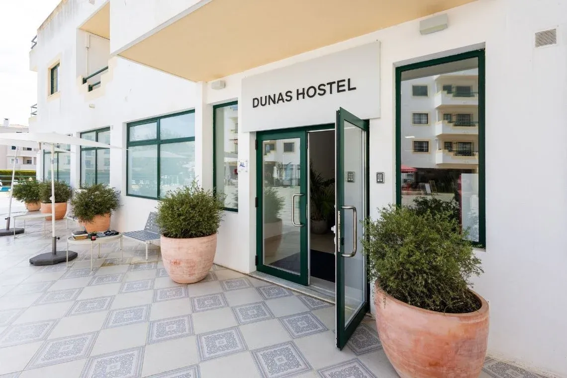 Bright hotel room with two beds, a colorful pillow, and a magazine. Torralvor: Corporativa