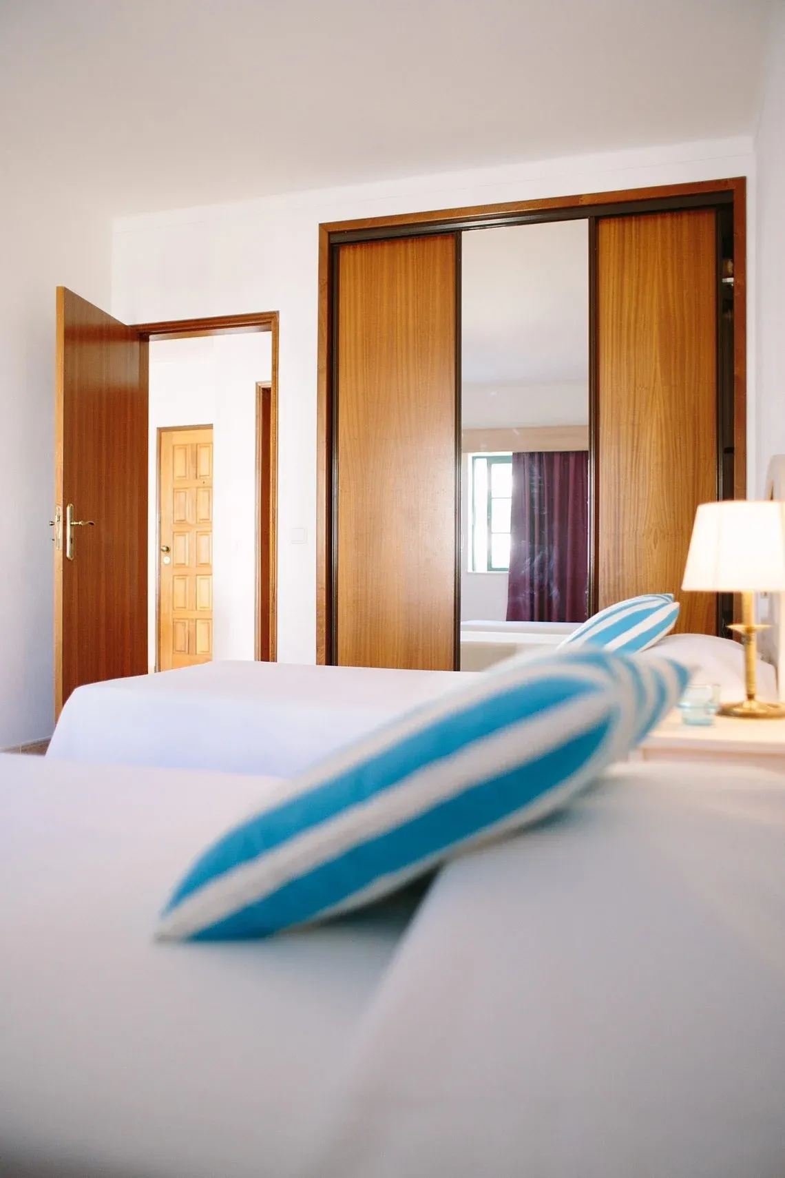 Habitación moderna con camas, puertas de madera yTorralvor: Corporativa armario de espejo.