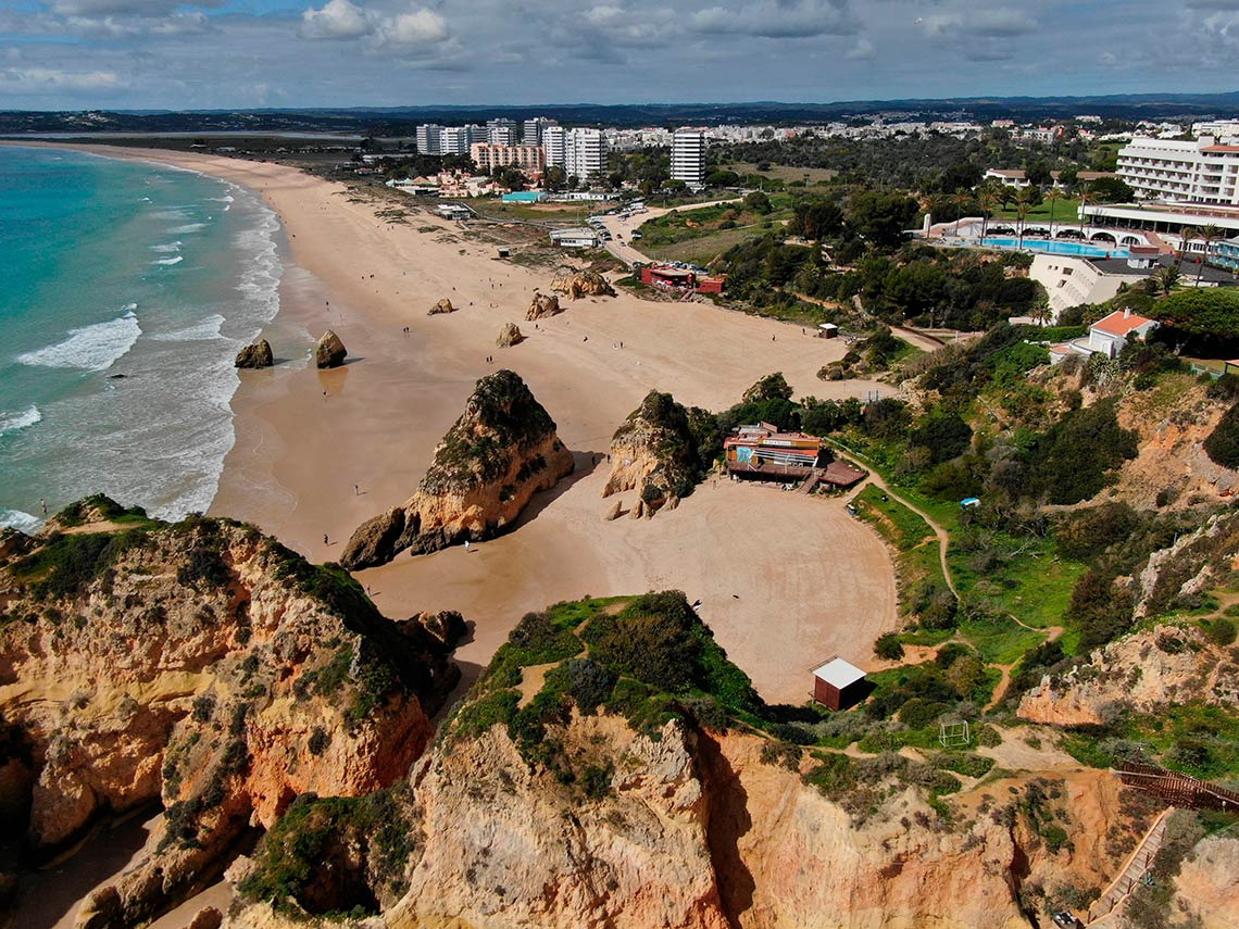 Vista aérea de praia em Portugal com hotel Torralvor: Corporativa e falésias.