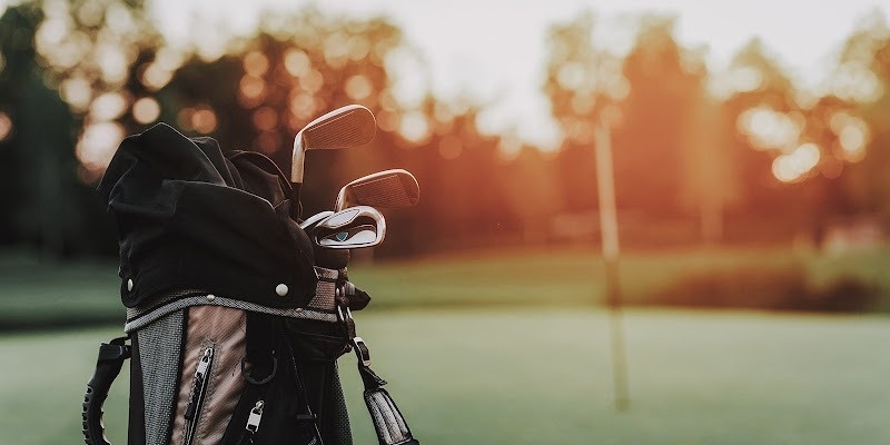 un grupo de golfistas están jugando en un campo de golf con una montaña en el fondo