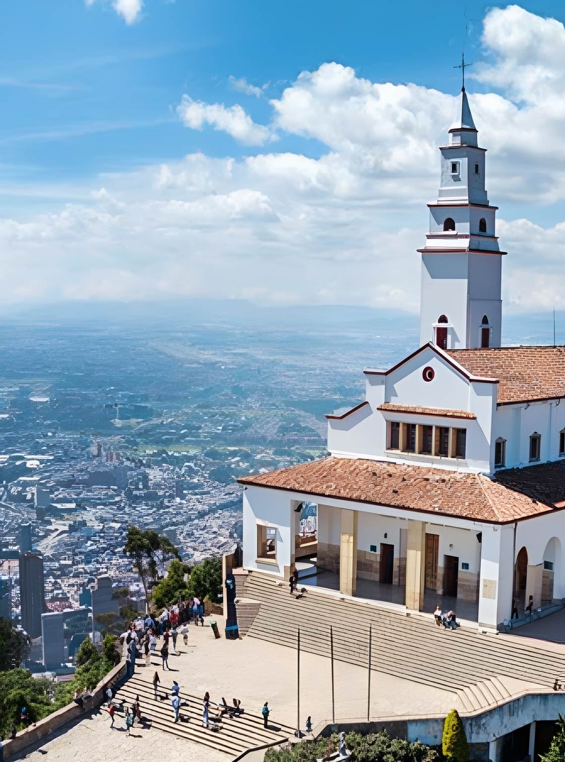 una vista aérea de una iglesia blanca con un techo de tejas rojas y una torre .