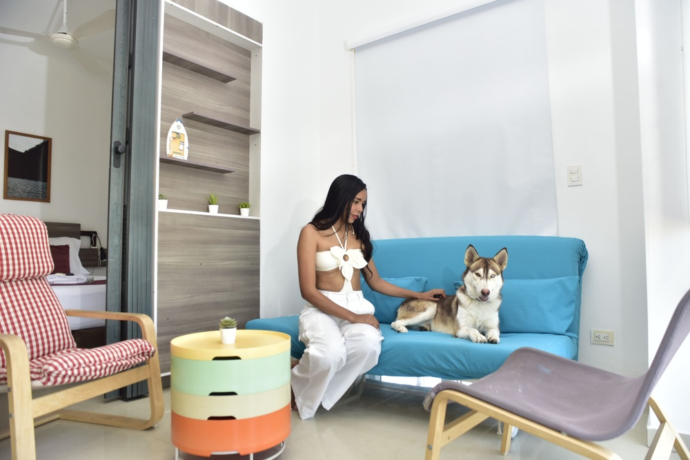 a woman sitting on a blue couch petting a dog