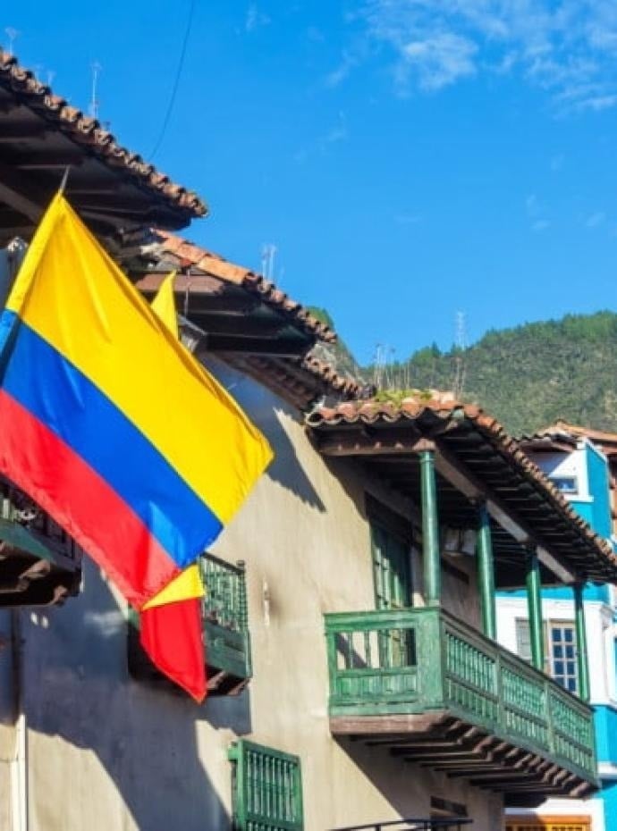 una bandera amarilla , roja y azul cuelga del techo de un edificio .