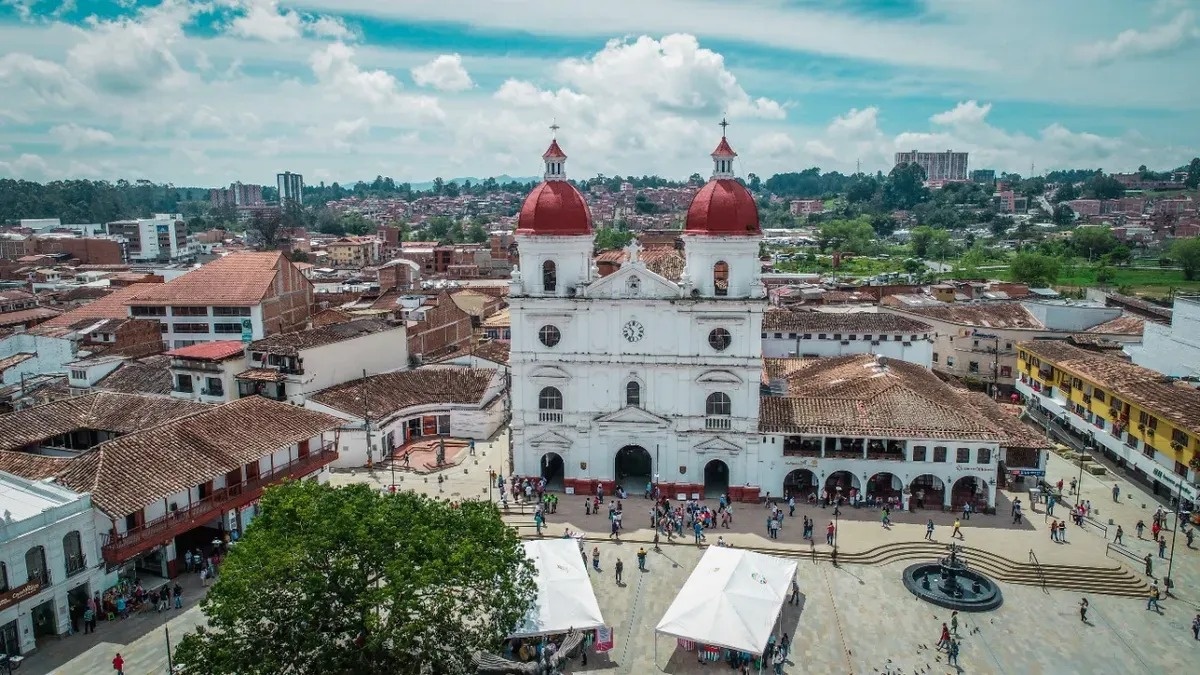 an aerial view of a white church with red domes