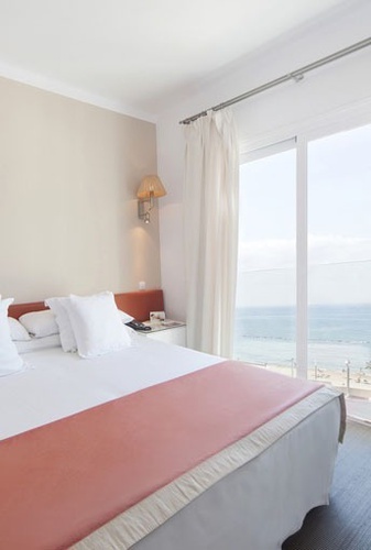 una habitación de hotel con una cama y una ventana con vista al océano .