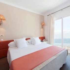 una habitación con una cama y una ventana con vista al océano
