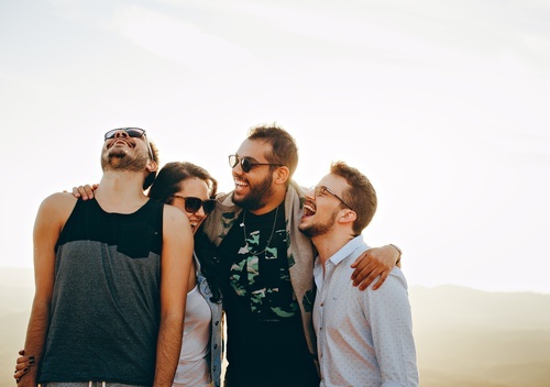 un grupo de jóvenes están parados uno al lado del otro y riendo .