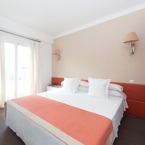 a hotel room with a bed and a flat screen tv