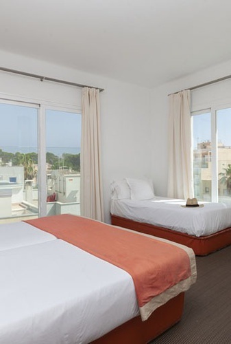 una habitación de hotel con dos camas y una ventana