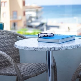 una mesa con un libro y gafas de sol sobre ella