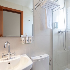 a bathroom with a sink toilet and shower with a dispenser that says nivea