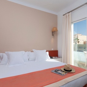 a hotel room with a bed and a hat on it