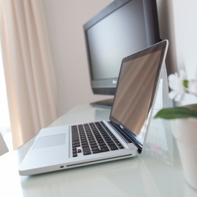 una computadora portátil está sobre una mesa junto a una televisión