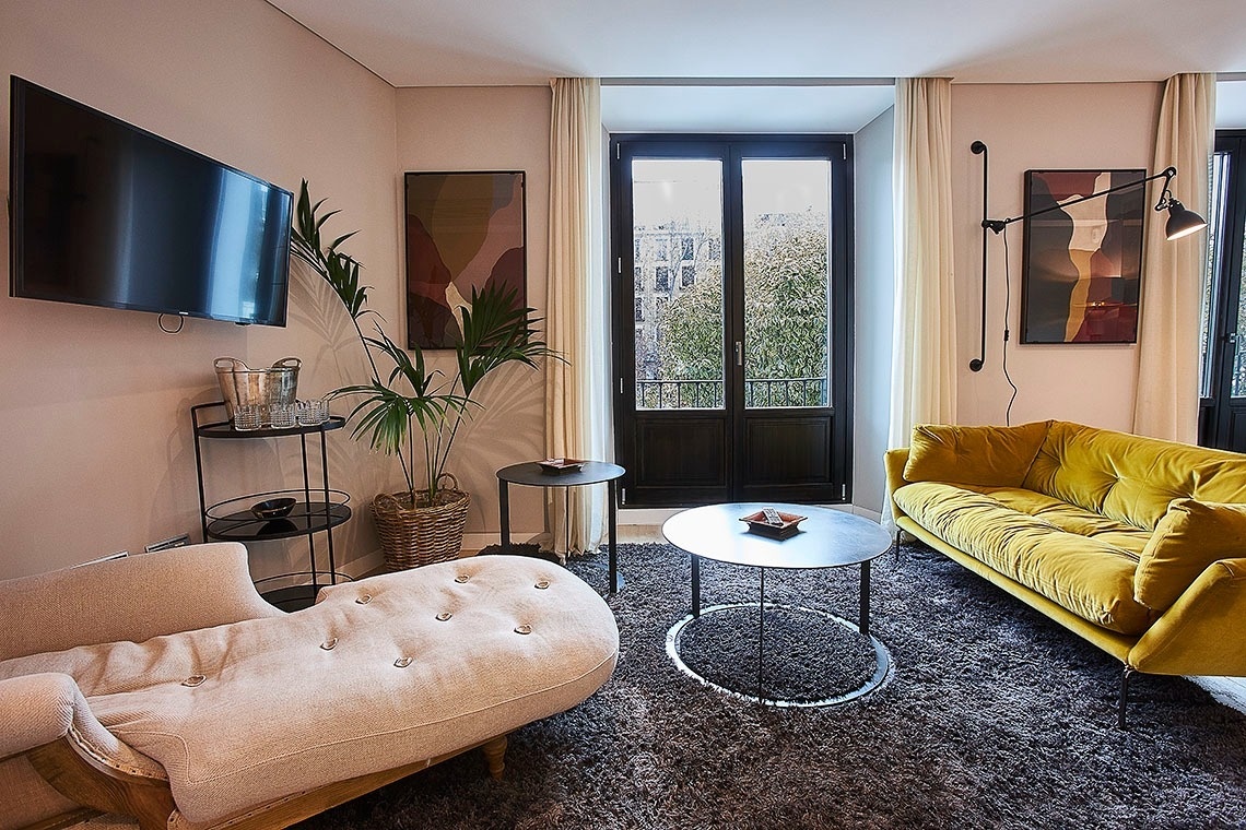 una sala de estar con un sofá amarillo y una televisión