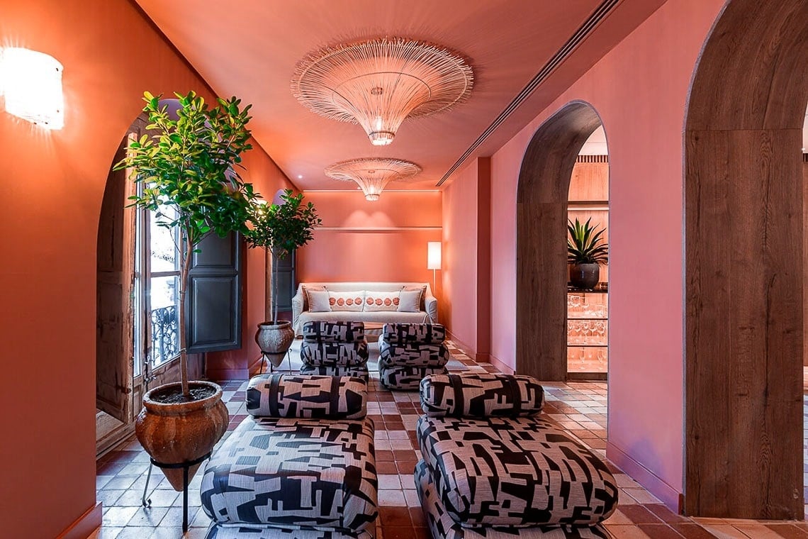 una habitación con paredes rosas y sillas estampadas