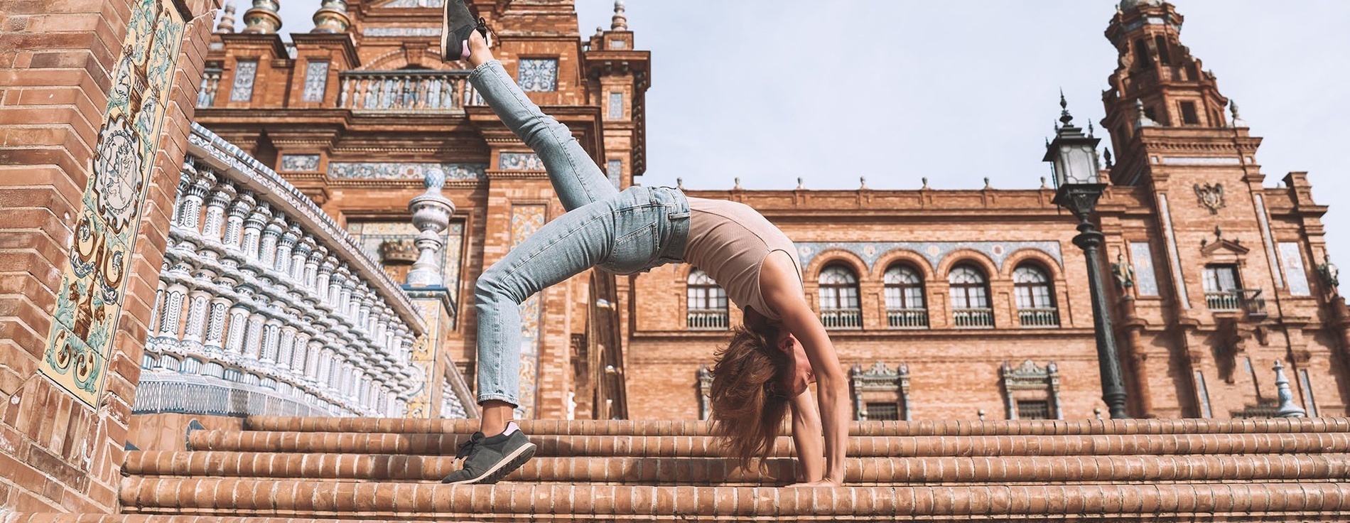 a woman is doing a handstand on a set of stairs