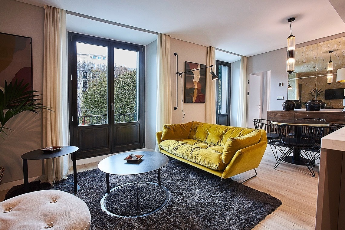 una sala de estar con un sofá amarillo y una mesa