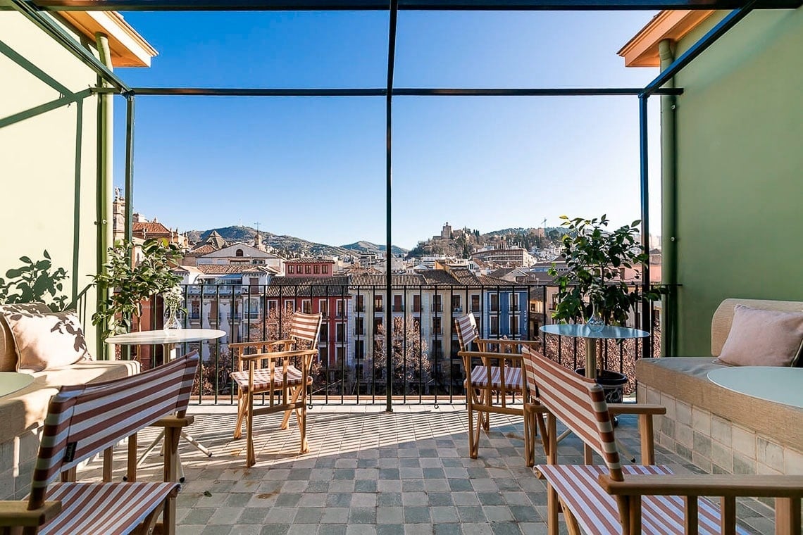 un balcón con sillas y mesas y una vista de la ciudad