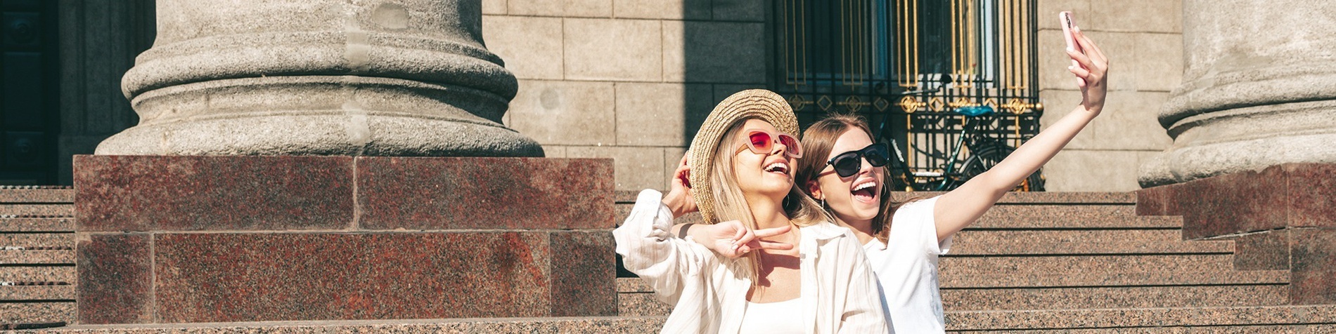 two women wearing sunglasses and hats are taking a selfie