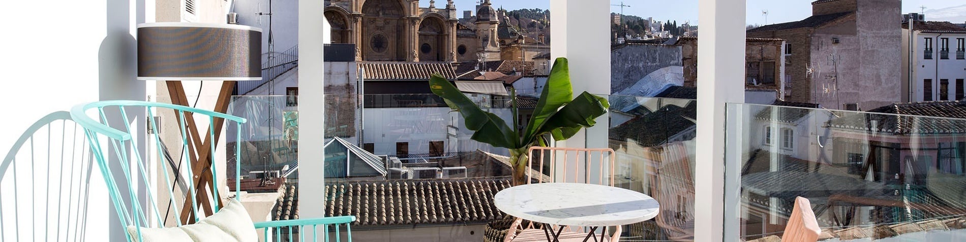 a view of a city from a balcony with a table and chairs