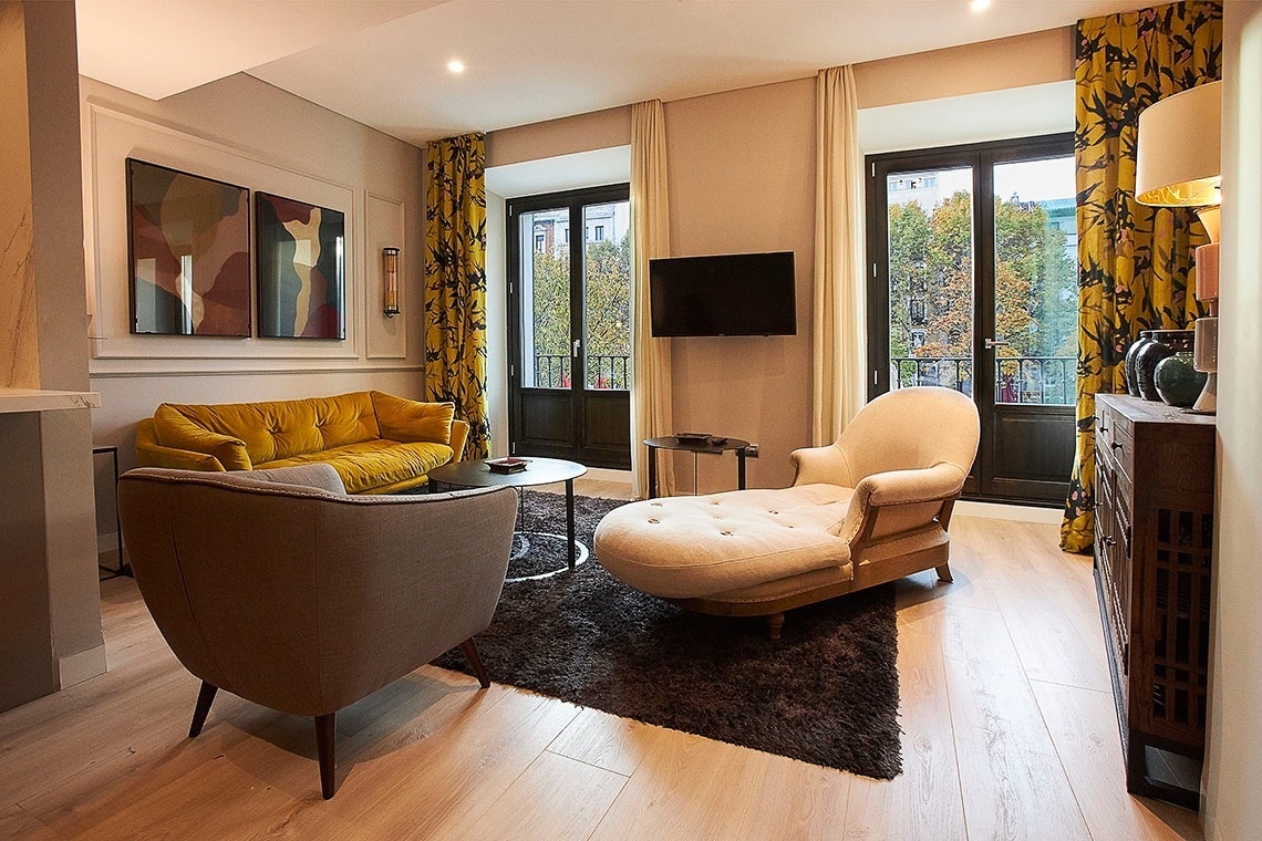 a living room with a yellow couch and two chairs