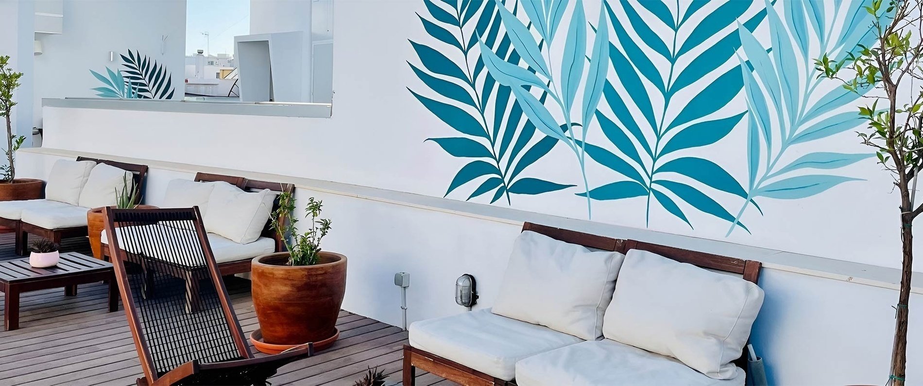 a group of people are walking down a narrow street in front of a building with a sign that says ' plaza '