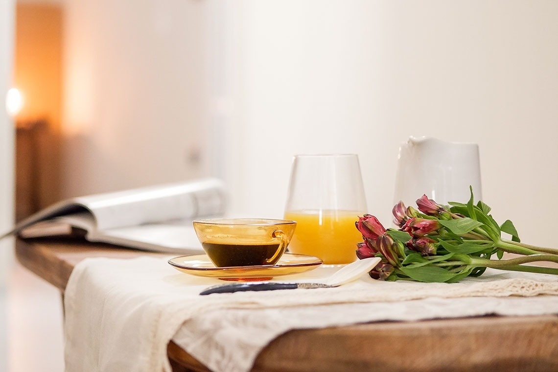 una mesa con una taza de café y un vaso de jugo de naranja