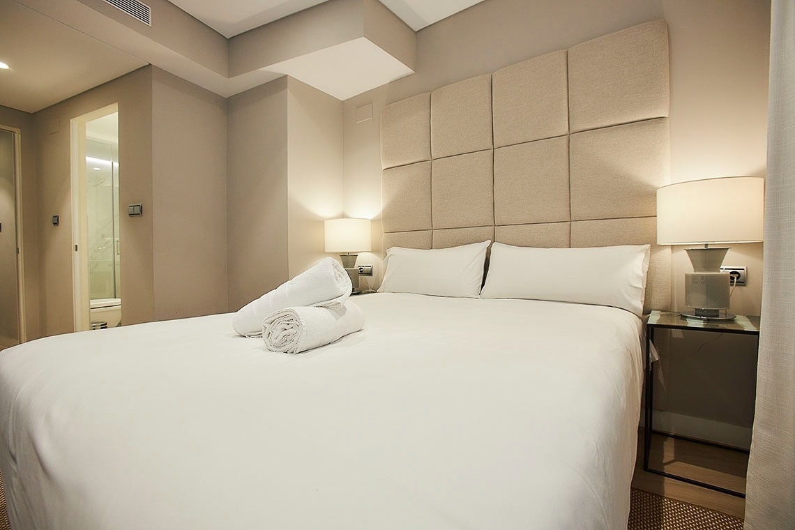 a hotel room with a bed and two lamps