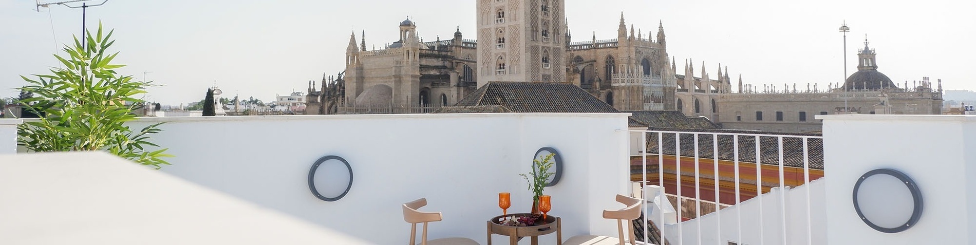 un balcón con una mesa y sillas y una vista de una catedral