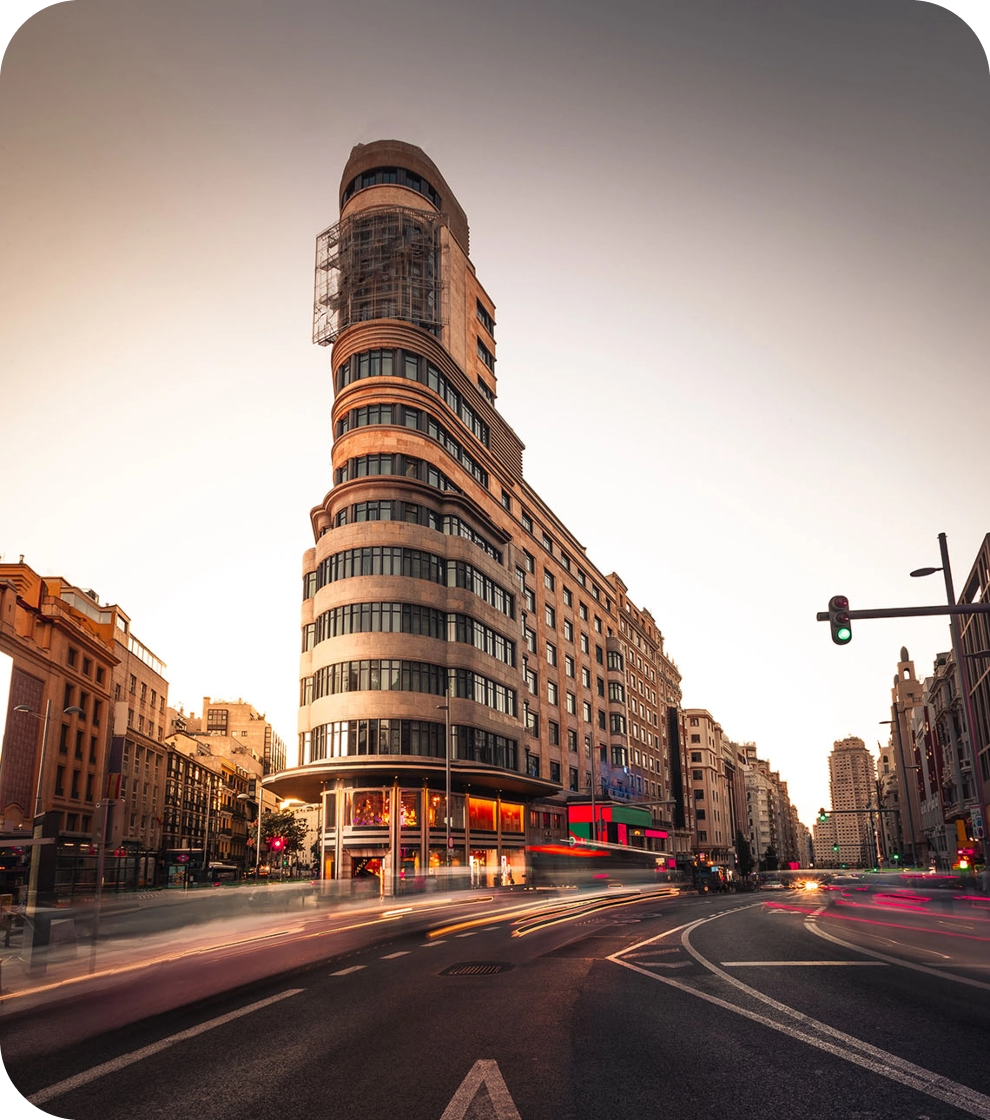 a busy city street with a large building in the background