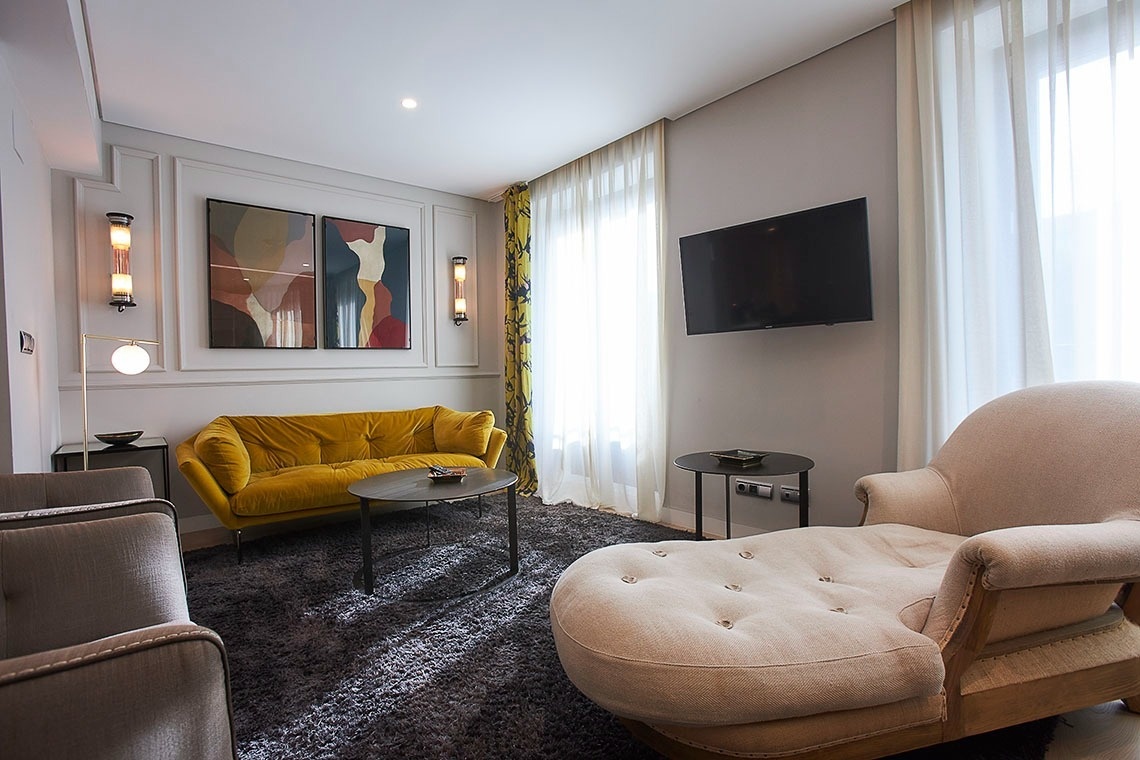 a living room with a yellow couch and a flat screen tv