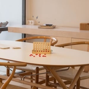 a white table with wooden chairs and a game on it