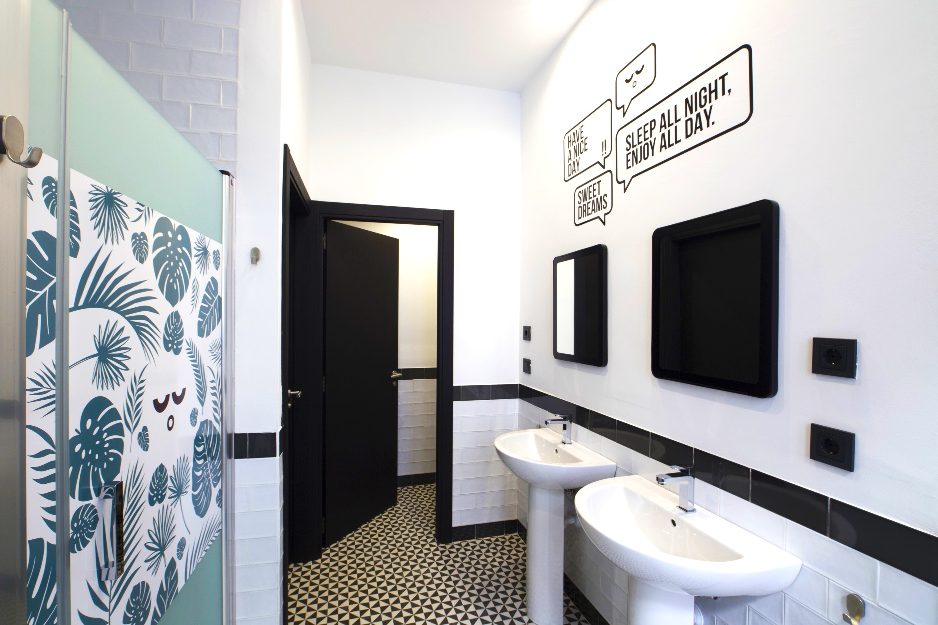 a bathroom with two sinks and a sign that says sleep all night enjoy all day