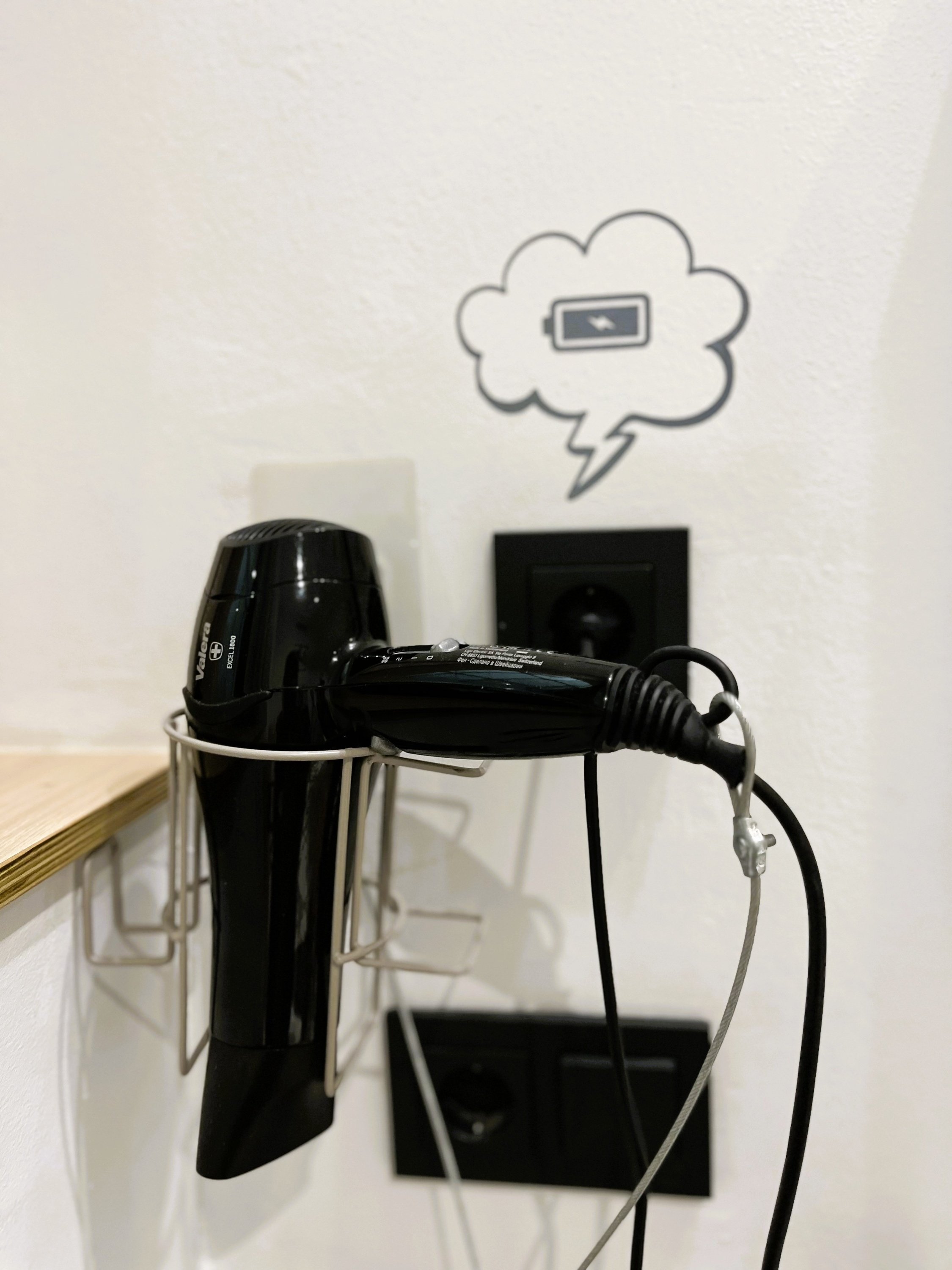 a black hair dryer is plugged into a wall socket