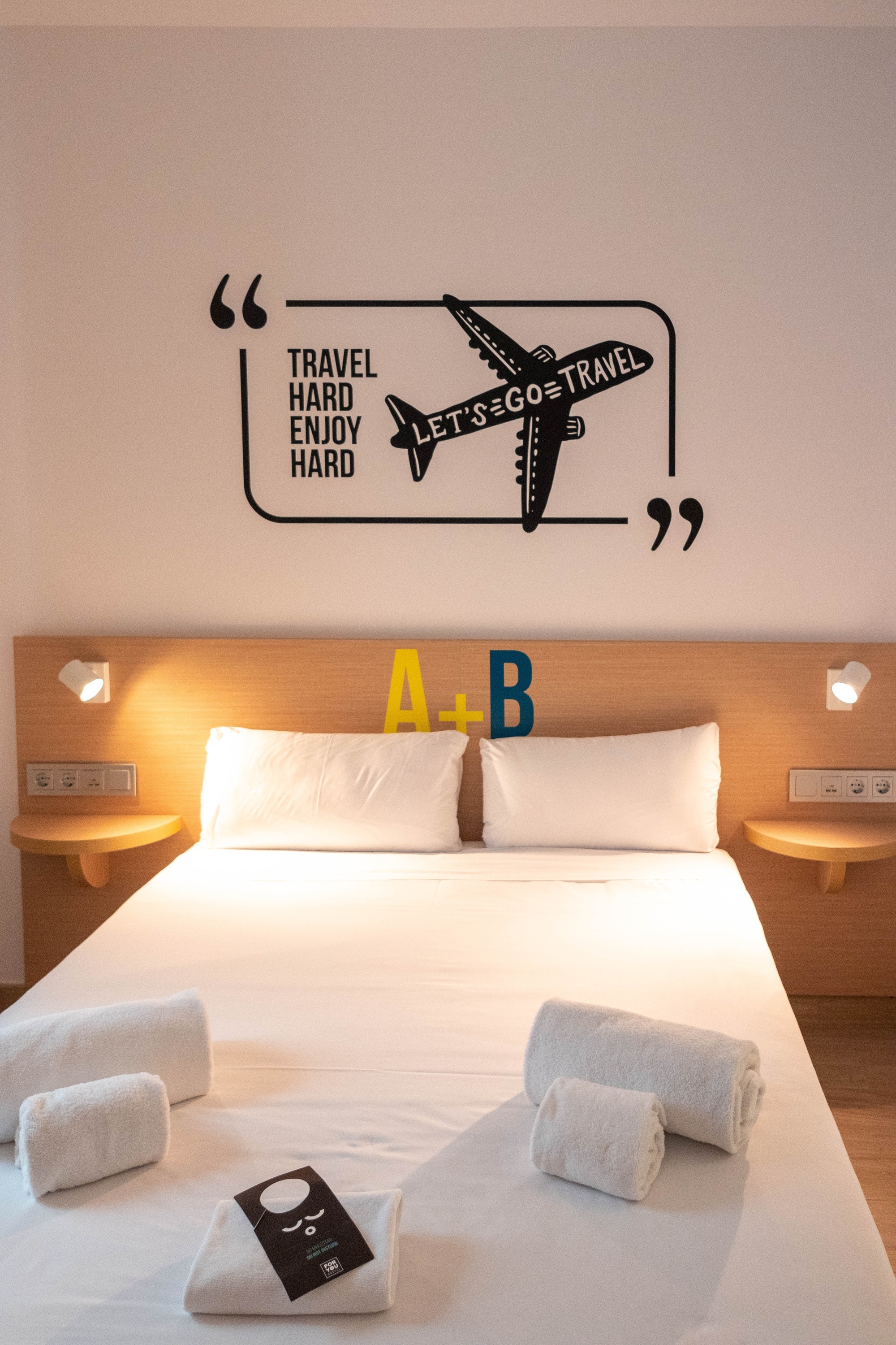 a hotel room with a quote on the wall that says travel hard enjoy hard