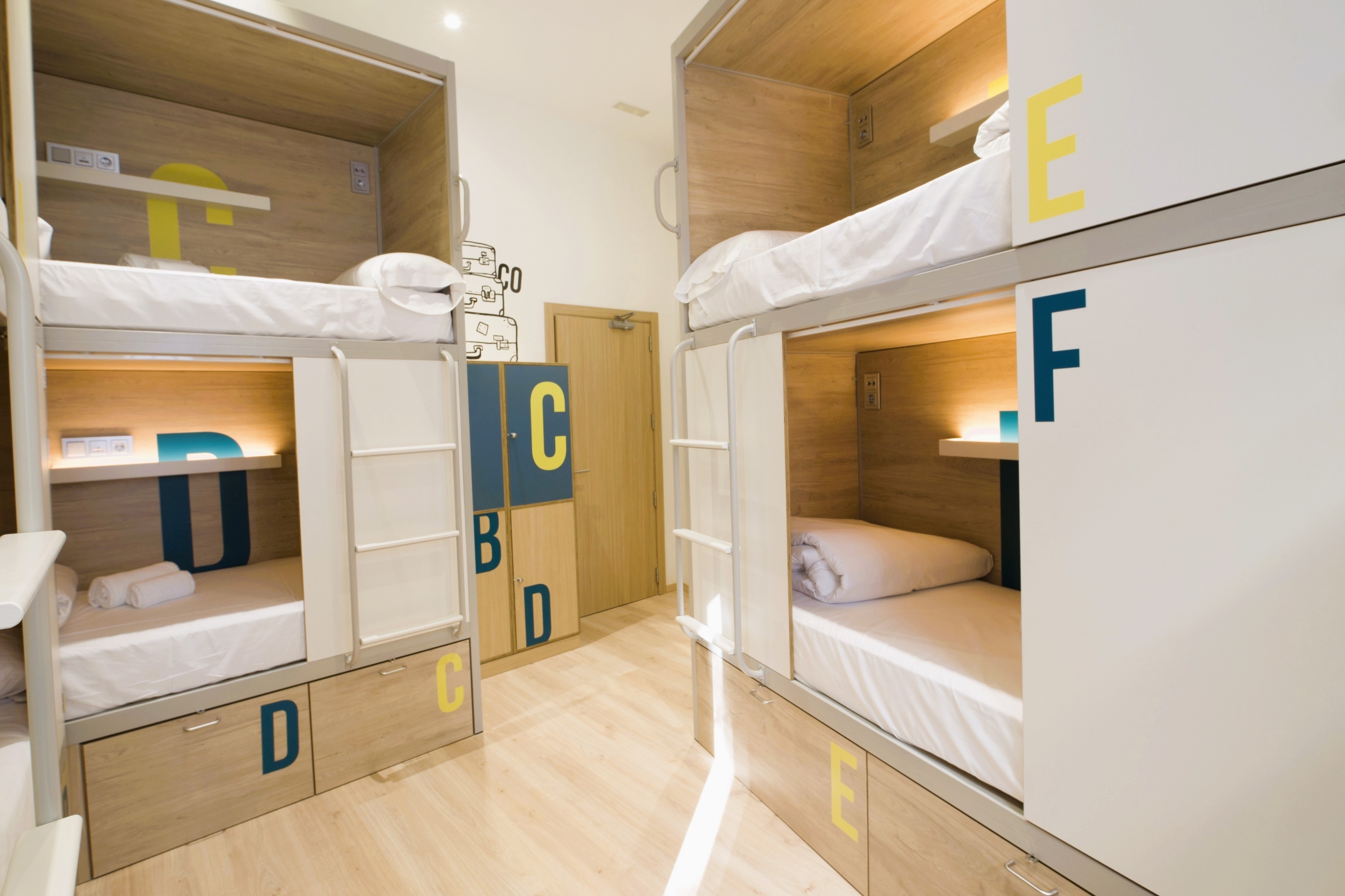 una habitación con literas y cajones con las letras c d e y f