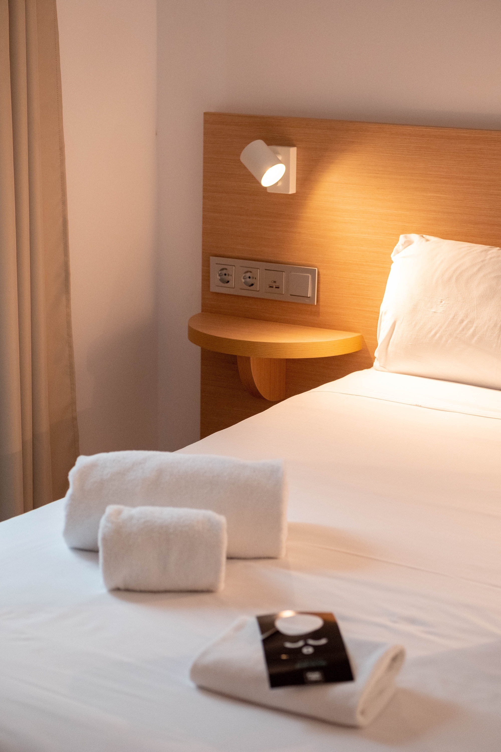 a bed with white towels and a book on it