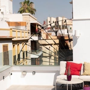 una terraza con muebles y mesas y una vista de la ciudad