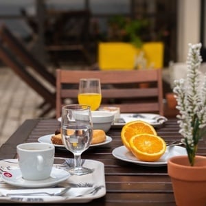 una mesa de madera con platos de comida y un vaso de jugo de naranja