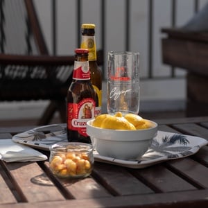una mesa de madera con una botella de cruzcampo y un vaso