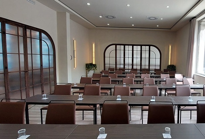 una sala de conferencias con una mesa larga y sillas