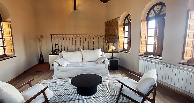Acogedor salón con sofá blanco y sillones en Palacio Valderrabanos.